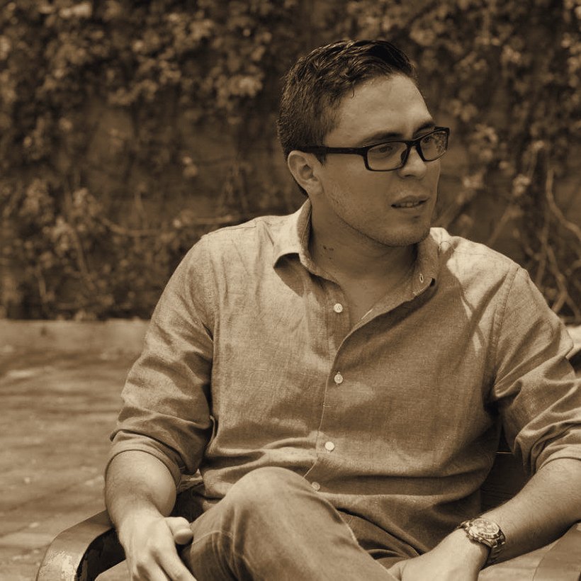 Oscar A. Jimenez Zavala sentado, en conversación